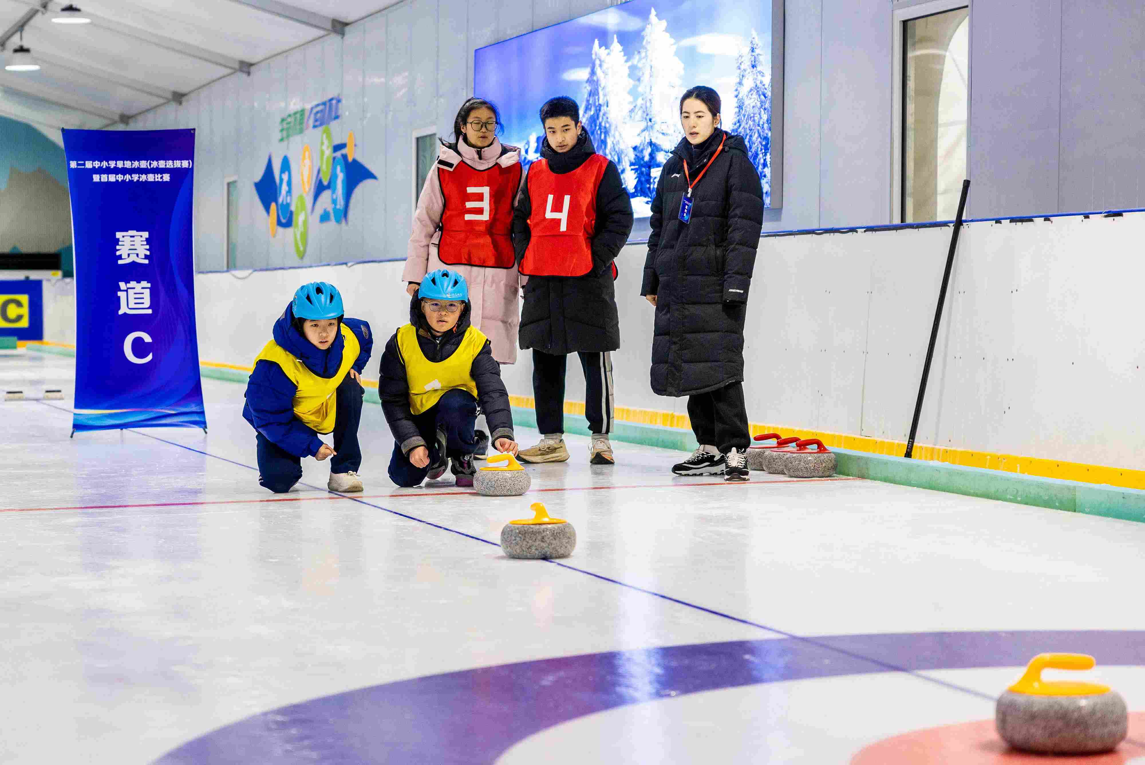 2023年12月10日，參賽選手在呼和浩特首屆中小學(xué)冰壺比賽中投擲冰壺。