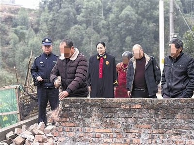  圖③：庭審結(jié)束后，在法官的見證下，陳某在院壩邊重新開鑿一條通道。