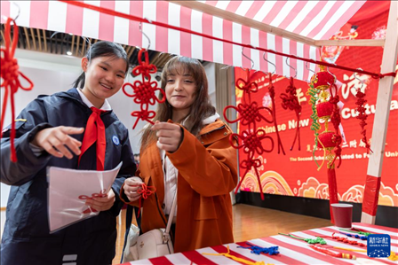 1月28日，復(fù)旦大學(xué)第二附屬學(xué)校學(xué)生（左）為美國(guó)馬斯卡廷中學(xué)學(xué)生（右）介紹中國(guó)結(jié)。 新華社記者 王翔 攝