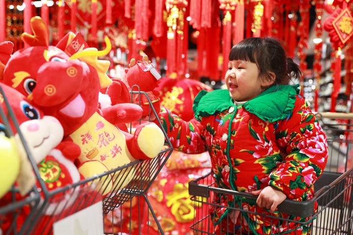 1月23日，在貴州省黔東南苗族侗族自治州岑鞏縣一家超市，小朋友在家人的帶領(lǐng)下選購(gòu)龍年毛絨玩具。新華社發(fā)（唐鵬攝）