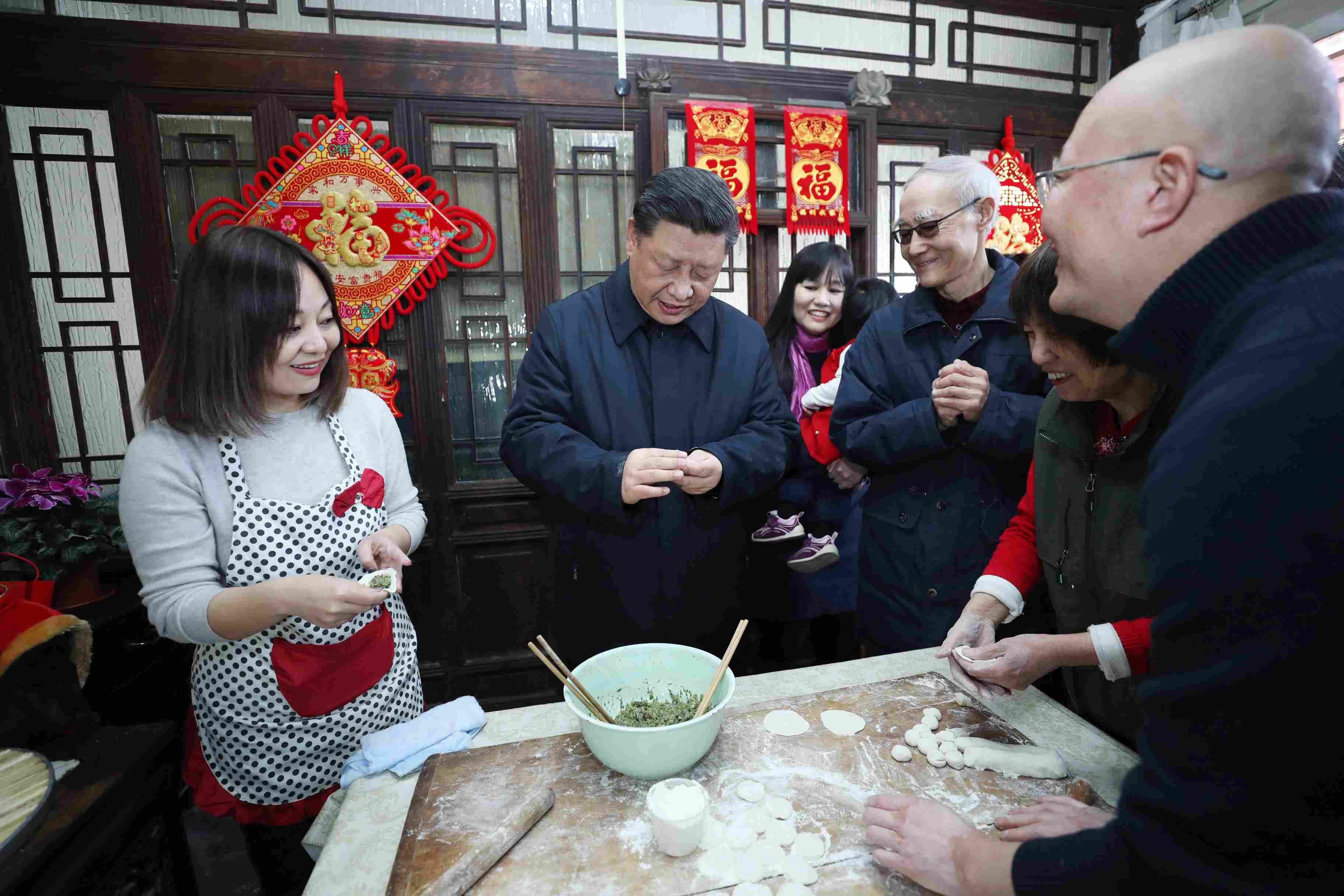 △ 2019年2月1日，習近平總書記在北京前門東區(qū)草廠四條胡同，同朱茂錦一家人包餃子、聊家常。