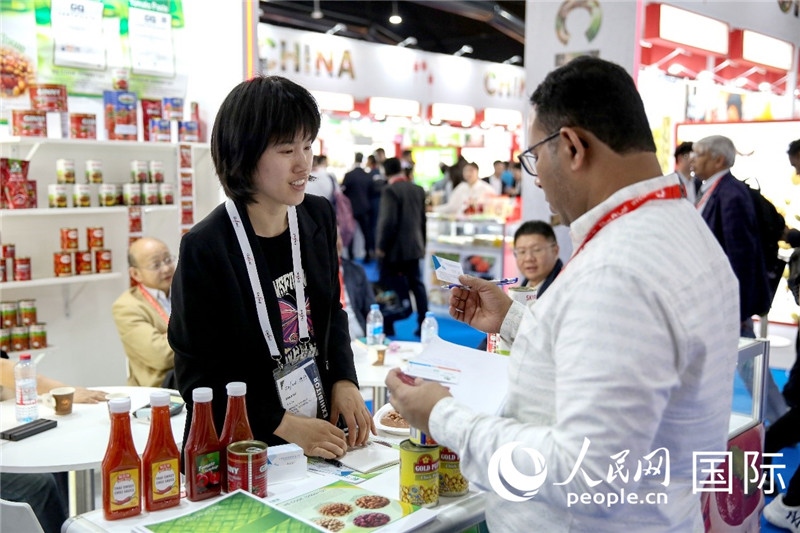 圖為中國參展企業(yè)代表與采購商交流。人民網(wǎng) 塔里克·易卜拉欣攝