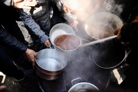  2月27日，在加沙地帶北部的杰巴利耶難民營，人們領(lǐng)取食物。新華社發(fā)（穆罕默德·阿里攝）