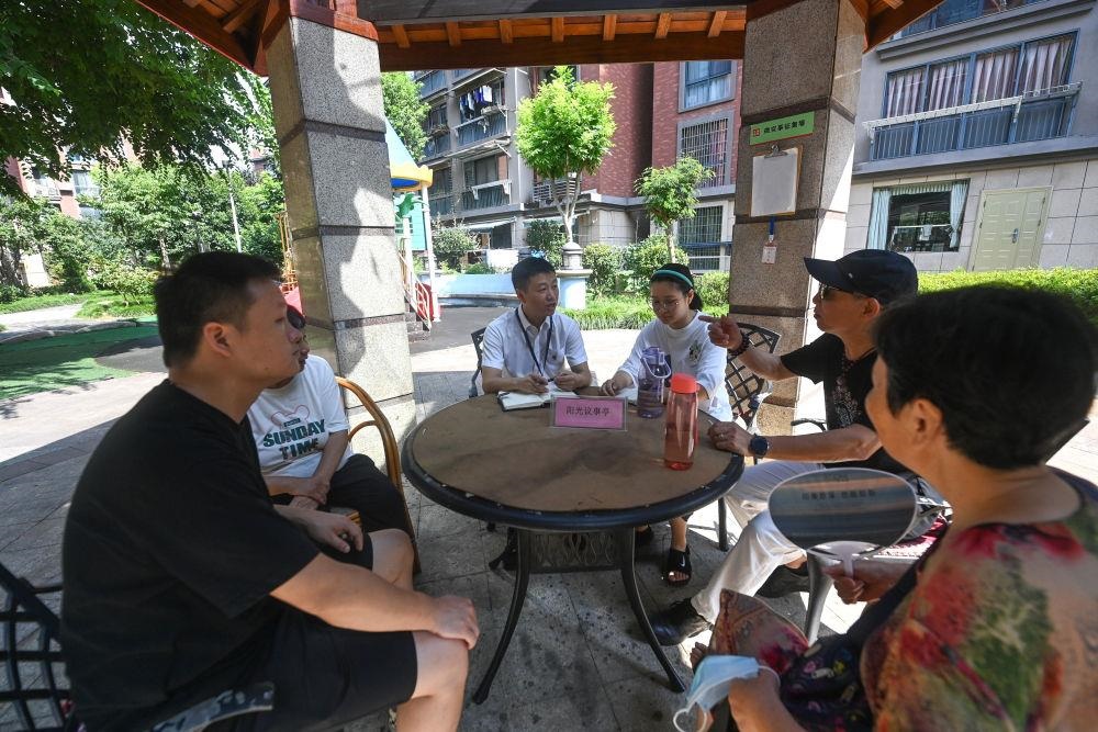 △2023年7月21日，在位于浙江杭州臨安區(qū)錦南街道水岸陽光小區(qū)的陽光議事廳，街道干部在聽取居民們反映的問題及意見。