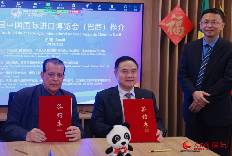巴西外貿(mào)商會聯(lián)合會會長阿代爾·羅伯托（左）與中國國際進口博覽局副局長吳政平（中）現(xiàn)場簽訂協(xié)議。人民網(wǎng)記者 宋亦然攝
