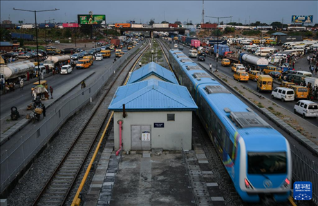 3月4日，在尼日利亞拉各斯，一列輕軌藍(lán)線列車行駛至公路交通擁堵路段附近。新華社記者 韓旭 攝
