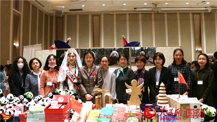 中國(guó)駐日本大使吳江浩夫人丁玥（左五）與使館人員在展位前合影留念。人民網(wǎng) 許可攝