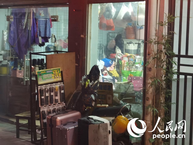 南寧“城中村”一裁縫鋪老板將電線從店內(nèi)拉出為電動(dòng)自行車充電。人民網(wǎng) 覃心攝