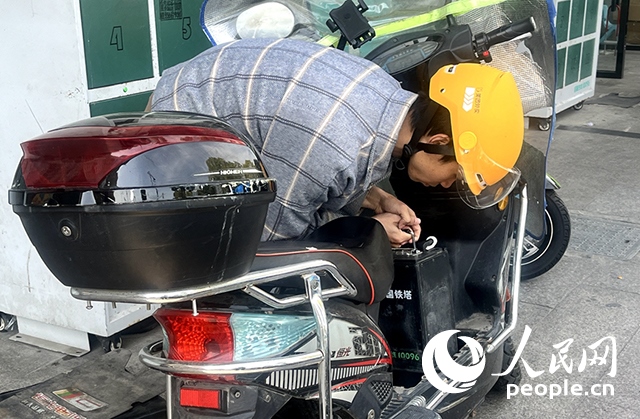 杭州一名外賣騎手正在更換共享電池。人民網(wǎng)記者 張麗瑋攝