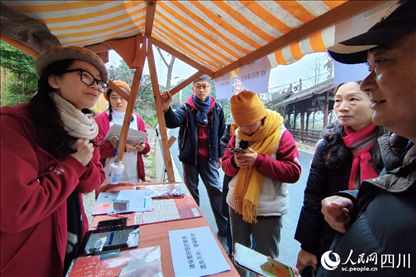 1月6日，“2024成都蒲江柑甜采摘節(jié)”上，記者見到了小萌（左一）和許多年輕人忙著做訪客接待、現(xiàn)場布置、票務核對、采摘服務等工作。人民網(wǎng)記者朱虹攝