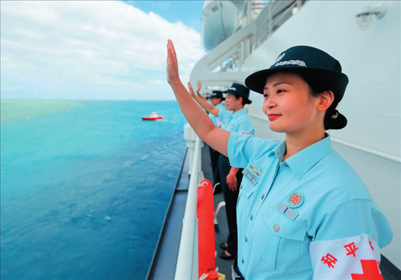 中國海軍“和平方舟”號(hào)醫(yī)院船結(jié)束訪問湯加時(shí)，任務(wù)官兵中的文職人員向歡送人群揮手告別（2023年8月4日攝）。徐巍攝/本刊
