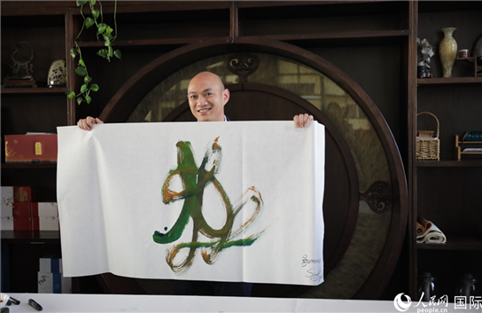 老撾駐華大使館三秘明君參加《五百筆·瀾湄合作》集體藝術(shù)創(chuàng)作。人民網(wǎng)王婧攝。