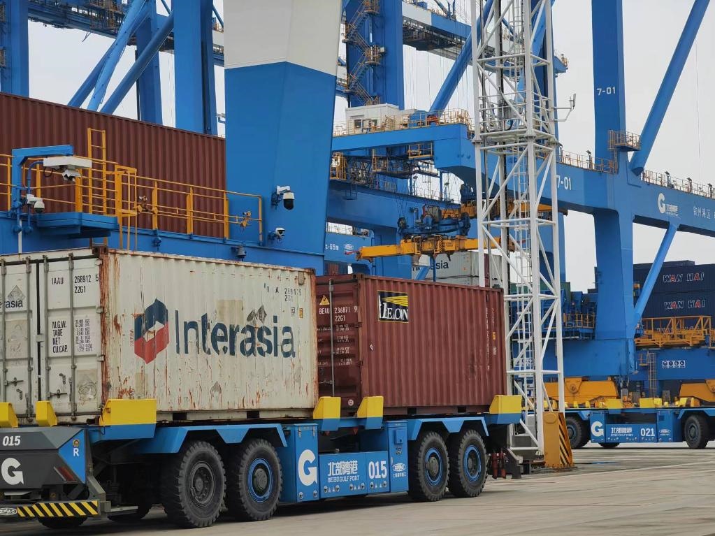 在欽州自動(dòng)化集裝箱碼頭，智能導(dǎo)引運(yùn)輸車在運(yùn)送集裝箱。新華社記者趙歡 攝