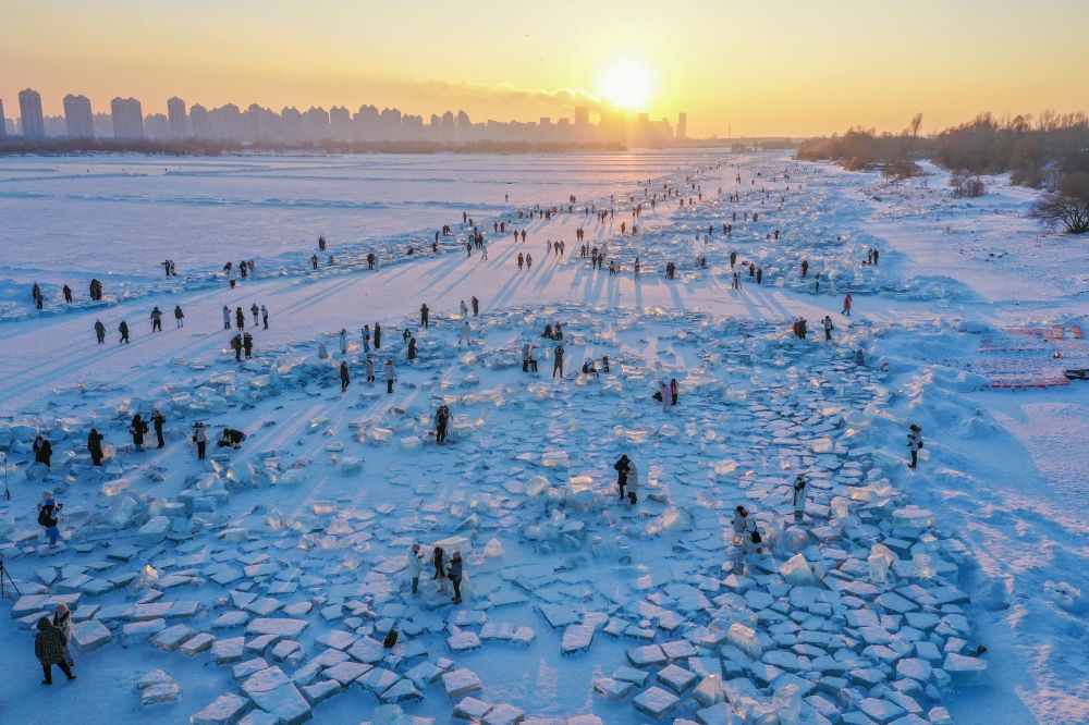 2024年1月7日，在封凍的松花江哈爾濱段，游客在日落時分的“鉆石海”游玩（無人機照片）。新華社記者 謝劍飛 攝