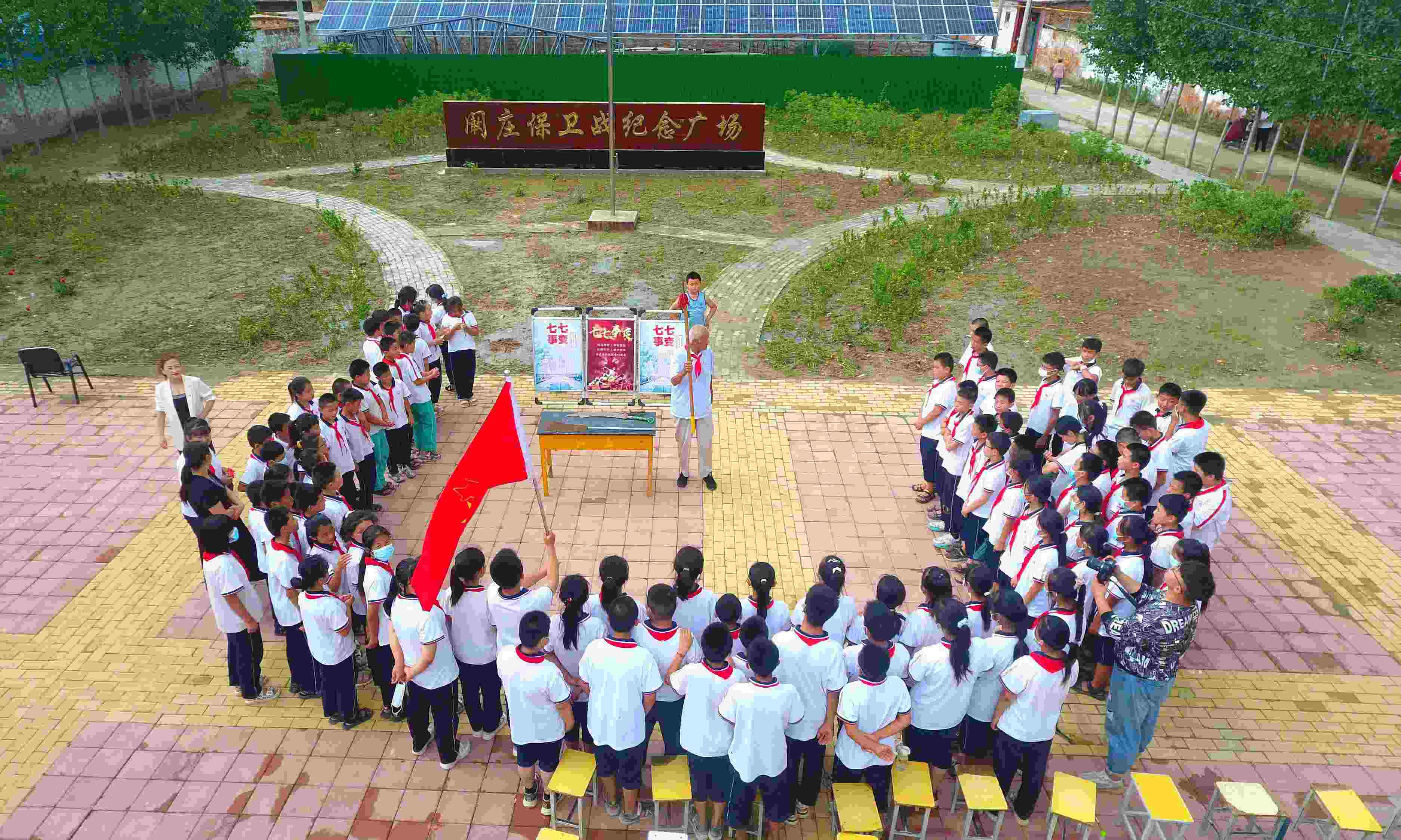 2022年7月6日，山東省聊城市，在茌平區(qū)菜屯鎮(zhèn)闞莊村的闞莊保衛(wèi)戰(zhàn)紀(jì)念廣場(chǎng)，闞莊保衛(wèi)戰(zhàn)親歷者王光木老人為小學(xué)生們講述抗戰(zhàn)故事，展示大刀、長(zhǎng)矛。