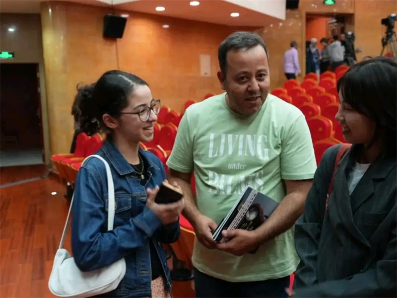阿爾及利亞市民拉納·艾薩尼和她父親現(xiàn)場聆聽中阿交響樂演出 。蘇州交響樂團(tuán)供圖