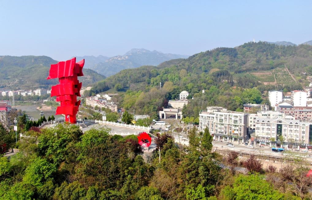 這是2021年4月9日拍攝的鄂豫皖蘇區(qū)首府革命博物館附近的英雄山上的“紅旗飄飄”主題雕塑（無人機(jī)照片）。新華社發(fā)