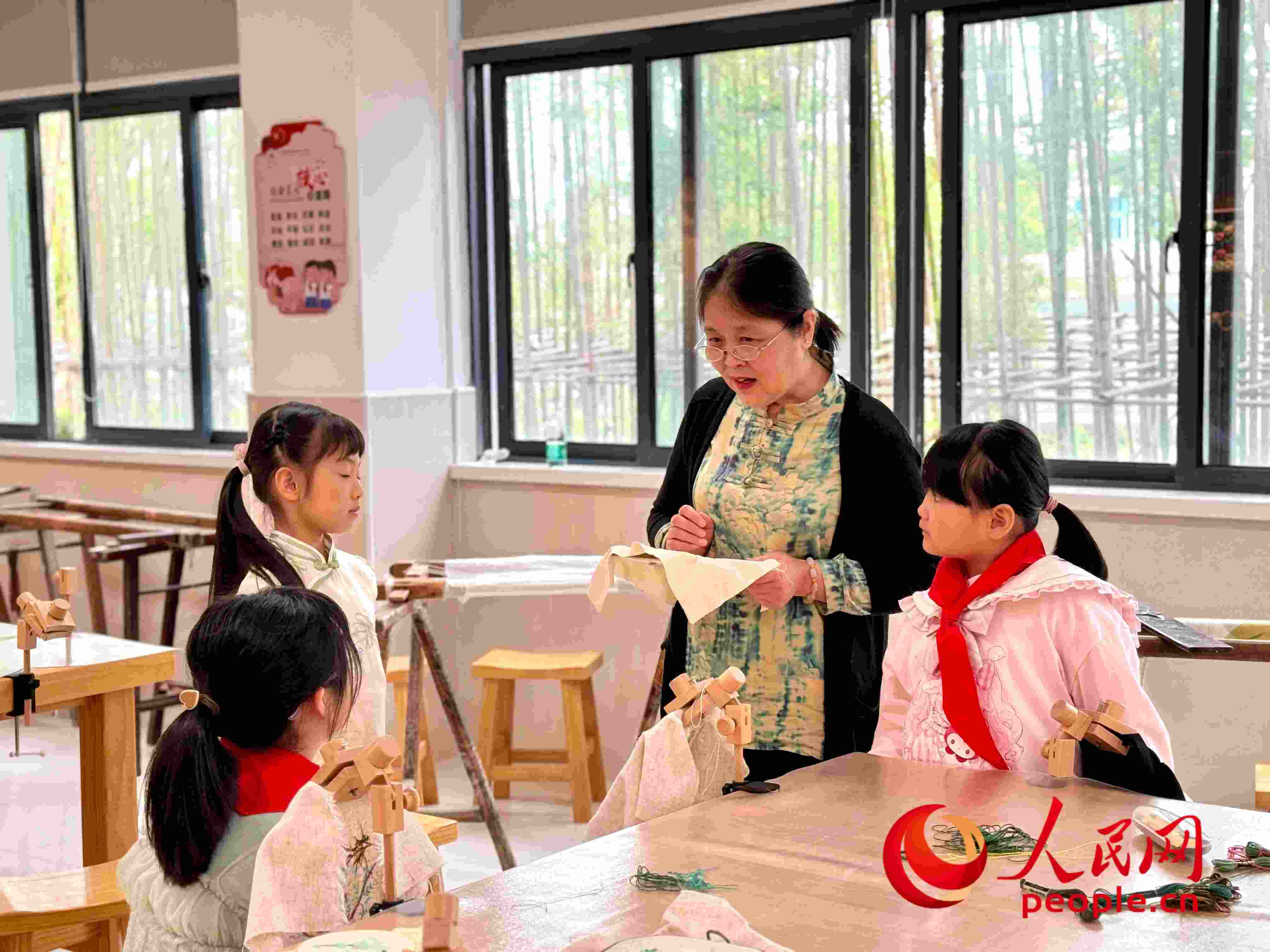顧建珍（左三）在教孩子們刺繡知識(shí)。人民網(wǎng) 周靜圓攝