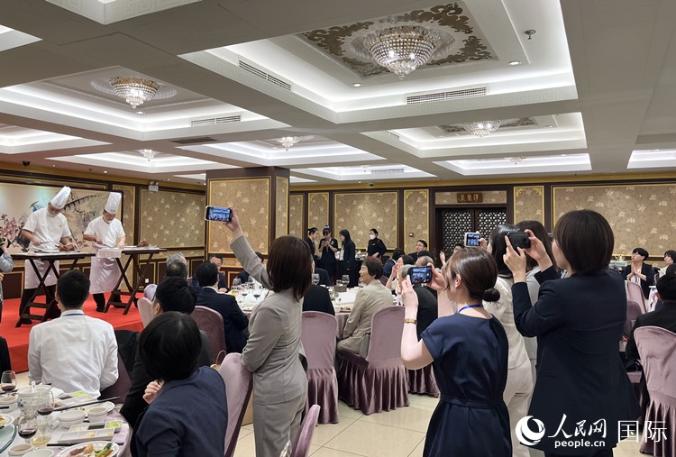國家級非物質文化遺產(chǎn)、全聚德片鴨工藝吸引代表團成員拍照留念。