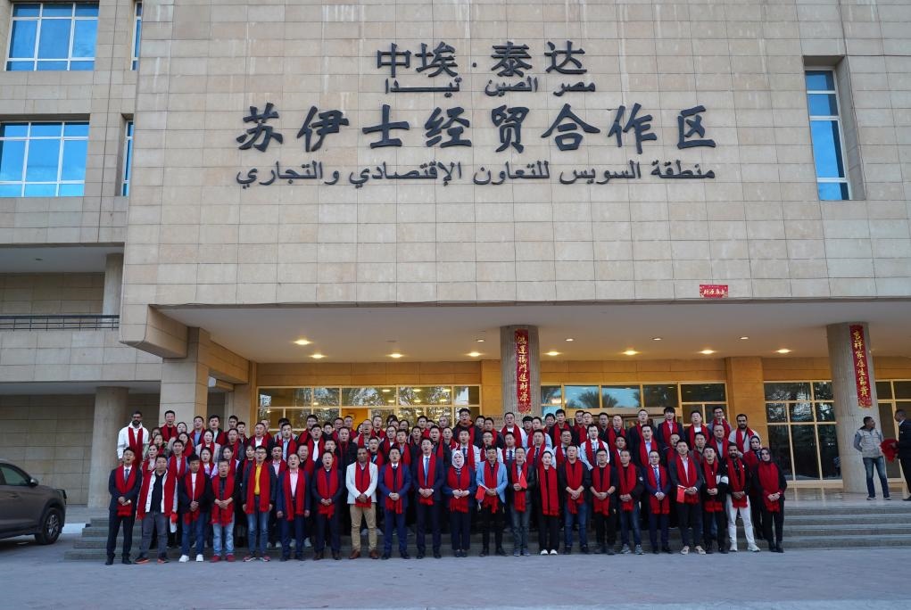 2024年2月11日，在位于埃及蘇伊士省的中?！ぬ┻_蘇伊士經貿合作區(qū)，中埃員工在合作區(qū)辦公大樓前合影拜年。新華社發(fā)（泰達合作區(qū)供圖）