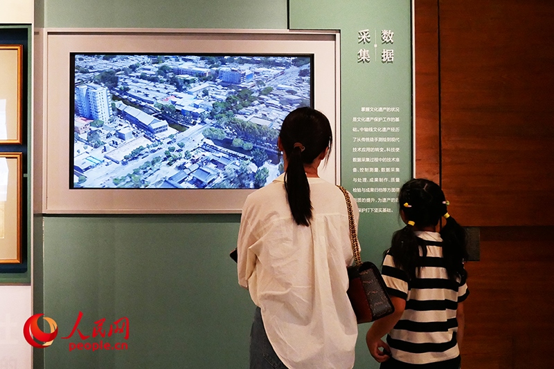 家長正在帶孩子參觀“輝煌中軸”專題展。人民網(wǎng)記者 韋衍行攝