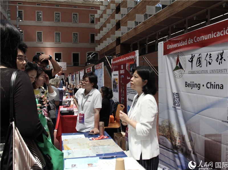 旅西華人華僑在展臺(tái)前咨詢。人民網(wǎng)記者 許海林?jǐn)z
