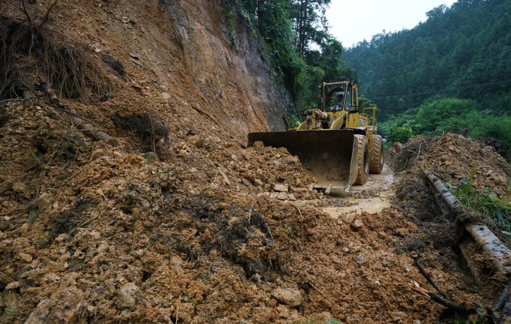 6月18日，在廣西融水苗族自治縣融水鎮(zhèn)新安村，一臺推土機在清理塌方路段。新華社發(fā)（龍林智攝）