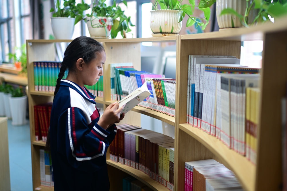 6月18日，果洛西寧民族中學(xué)學(xué)生尼東拉毛在圖書室看書。
