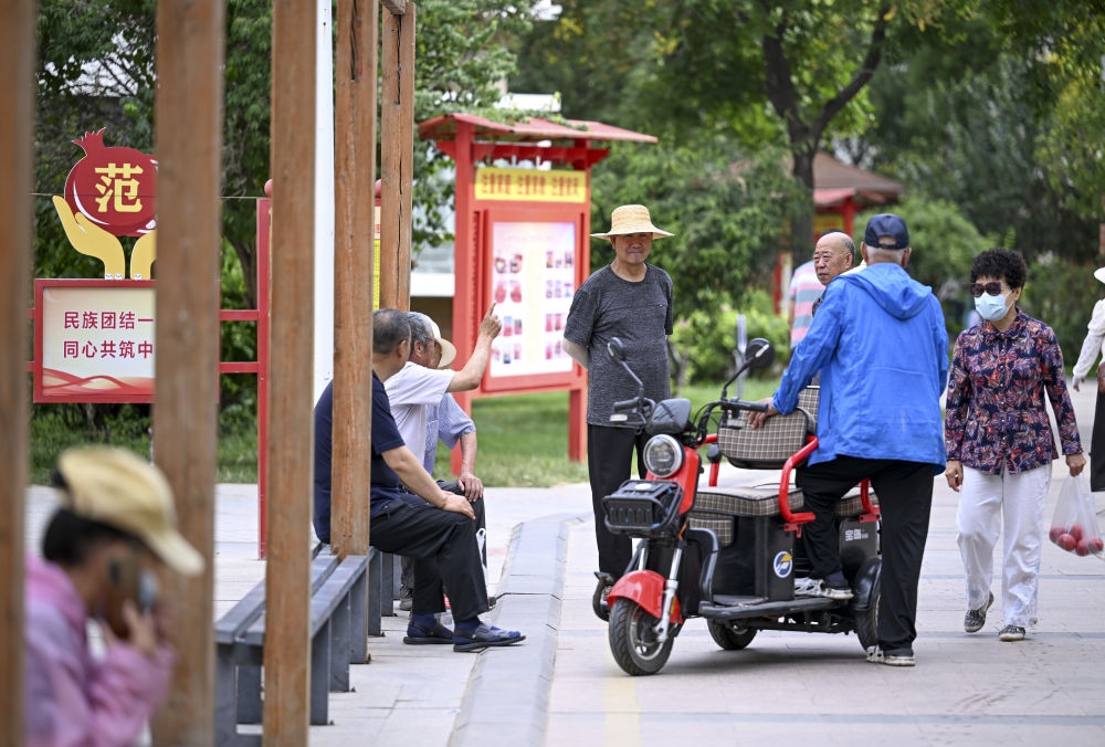 6月20日，長(zhǎng)城花園社區(qū)的居民在休閑、聊天。