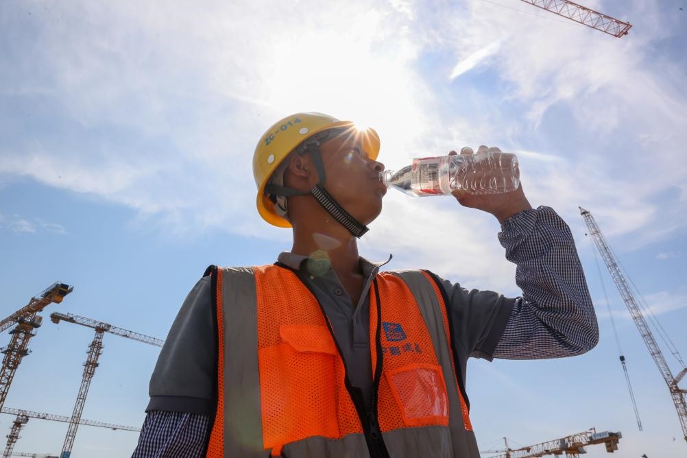 6月18日，在江蘇省無錫市奧體三期項目施工現(xiàn)場，中建二局工人在喝水解暑。新華社發(fā)（朱吉鵬 攝）