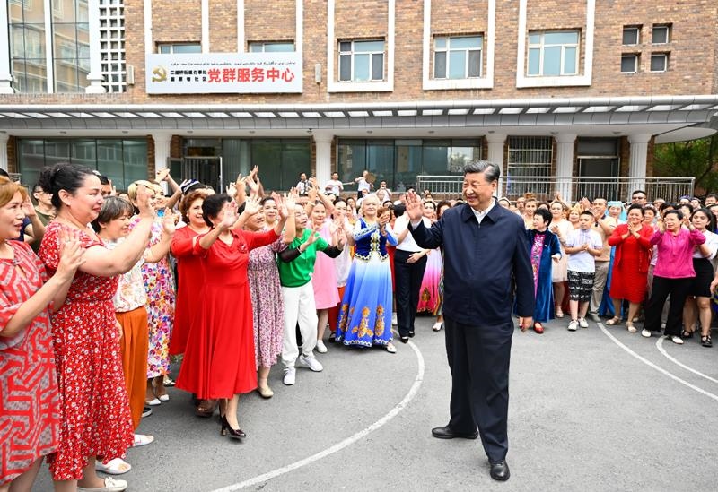 2022年7月13日，習(xí)近平總書記在新疆烏魯木齊市天山區(qū)固原巷社區(qū)考察時(shí)，向各族群眾揮手致意。