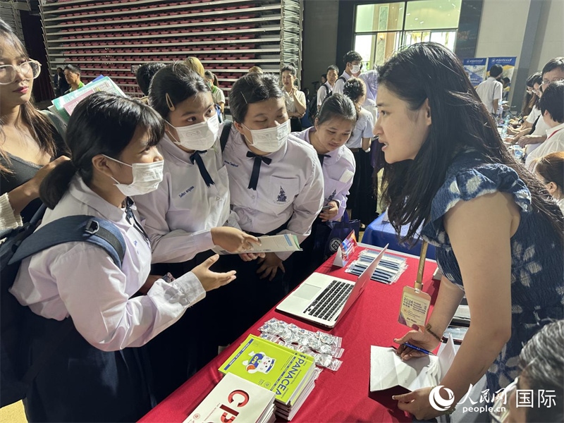 來自泰國的學(xué)生、家長在教育展臺前咨詢。人民網(wǎng)記者 簡承淵攝
