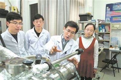 2017年10月，清華大學(xué)低維量子物理國(guó)家重點(diǎn)實(shí)驗(yàn)室，薛其坤（左三）與學(xué)生討論實(shí)驗(yàn)工作。 苑潔攝