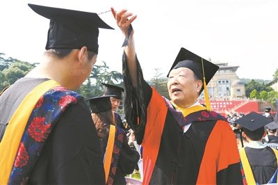 2017年6月22日，李德仁（右一）參加武漢大學(xué)畢業(yè)典禮并為畢業(yè)生撥穗。