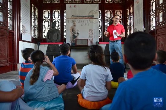 7月4日，在馬耳他桑塔露琪亞市的中國古典園林“靜園”，人們聆聽關(guān)于兵馬俑的講解。新華社發(fā)（喬納森·博格 攝）