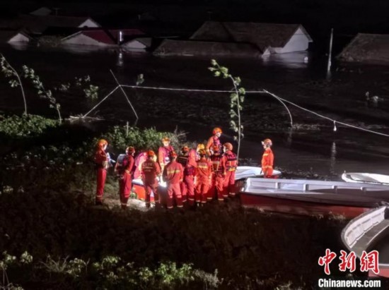  7月6日凌晨3時(shí)，在湖南岳陽華容縣團(tuán)洲垸洞庭湖一線堤防，救援人員剛剛完成一次救援任務(wù)，遠(yuǎn)處是被淹的民房。中新社記者 白祖偕 攝