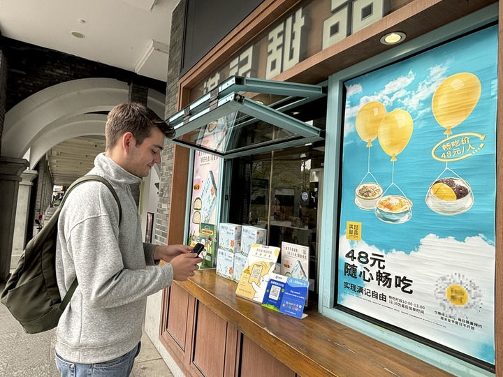 來自德國的留學生理查德在杭州西湖邊一家商鋪使用支付寶掃碼支付（2024年4月11日攝）。新華社發(fā)