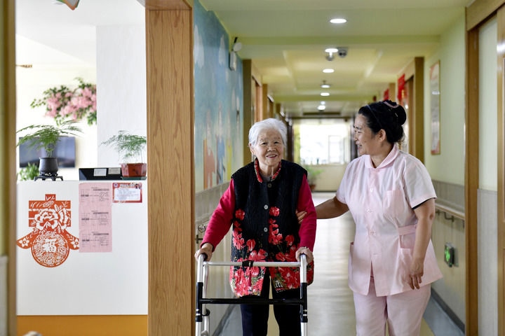 2024年5月25日，在山東省日照市東港區(qū)石臼街道日照幸福護(hù)理院，工作人員在陪護(hù)老人。新華社記者 郭緒雷 攝