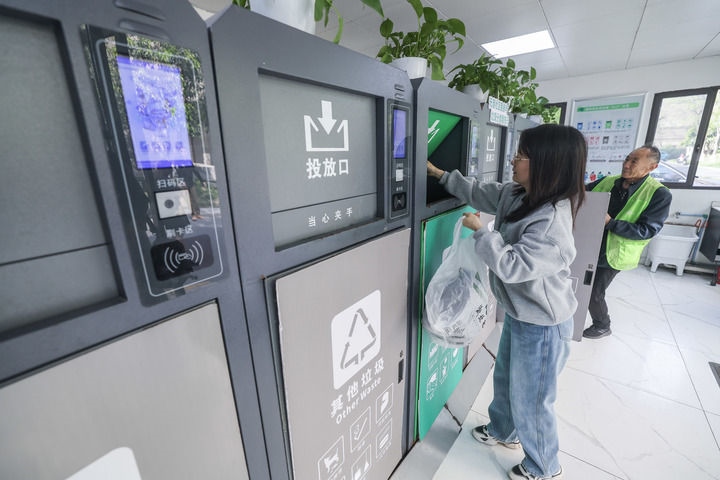 2024年4月10日，在浙江省湖州市吳興區(qū)飛英街道新華府小區(qū)內(nèi)，居民在垃圾分類智能系統(tǒng)的指導(dǎo)下進(jìn)行垃圾分類投放，居民的投放情況將實(shí)時匯總到智慧服務(wù)平臺，會有相應(yīng)的積分獎勵。新華社記者 徐昱 攝