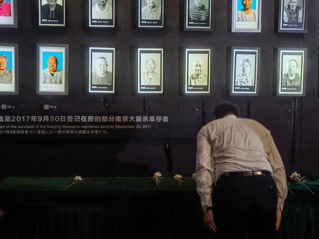 7月18日，人們向離世的南京大屠殺幸存者獻花、鞠躬。新華社記者邱冰清 攝