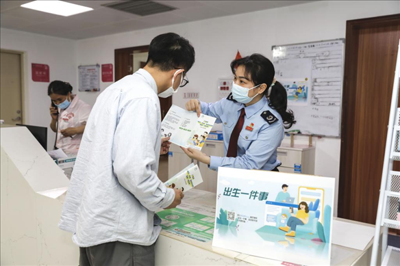 志愿者為葉先生介紹新生兒相關(guān)服務。云浮市稅務局供圖