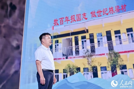 張玉滾分享用一根扁擔(dān)送孩子們走出大山的故事。人民網(wǎng)攝