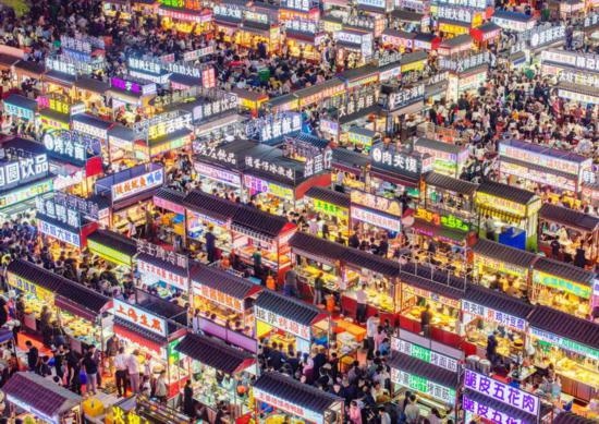2024年4月21日，人們?cè)诤颖笔≌h小商品夜市品嘗美食（無(wú)人機(jī)照片）。新華社發(fā)（武志偉 攝）