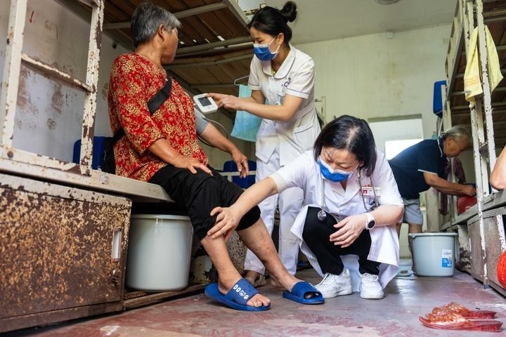 2024年7月30日，在湖南省湘潭縣河口中學(xué)安置點(diǎn)，醫(yī)務(wù)人員為受洪水影響而轉(zhuǎn)移安置的群眾檢查身體。 新華社記者 陳思汗 攝