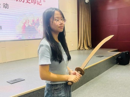 圖為南開(kāi)大學(xué)社會(huì)實(shí)踐隊(duì)學(xué)生代表呼月紅在學(xué)術(shù)交流活動(dòng)現(xiàn)場(chǎng)，展示河間調(diào)研行中獲贈(zèng)的一戰(zhàn)華工蔡世春曾使用過(guò)的一把大刀。林卓瑋 攝