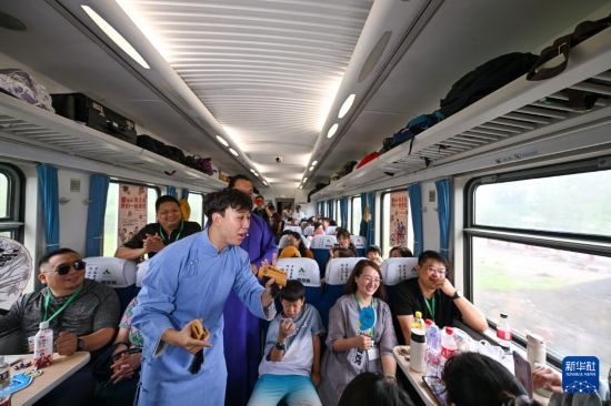 9月7日，相聲演員在S910列車上為旅客表演快板。