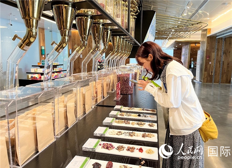 4. 代表團(tuán)團(tuán)員對(duì)新中式茶飲的食材充滿興趣。（人民網(wǎng)記者陳思 攝）