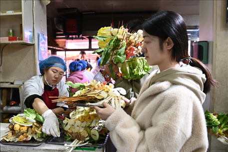 游客挑選好麻辣燙菜品后排隊(duì)等待加工。新華社記者 范培珅 攝