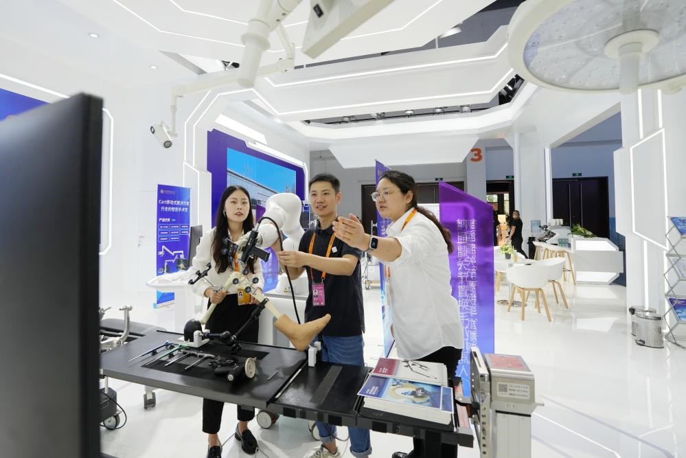9月11日，一位媒體記者（中）在2024年服貿(mào)會(huì)國家會(huì)議中心會(huì)場(chǎng)體驗(yàn)北京納通科技集團(tuán)有限公司的膝關(guān)節(jié)置換手術(shù)機(jī)器人。新華社記者鞠煥宗 攝