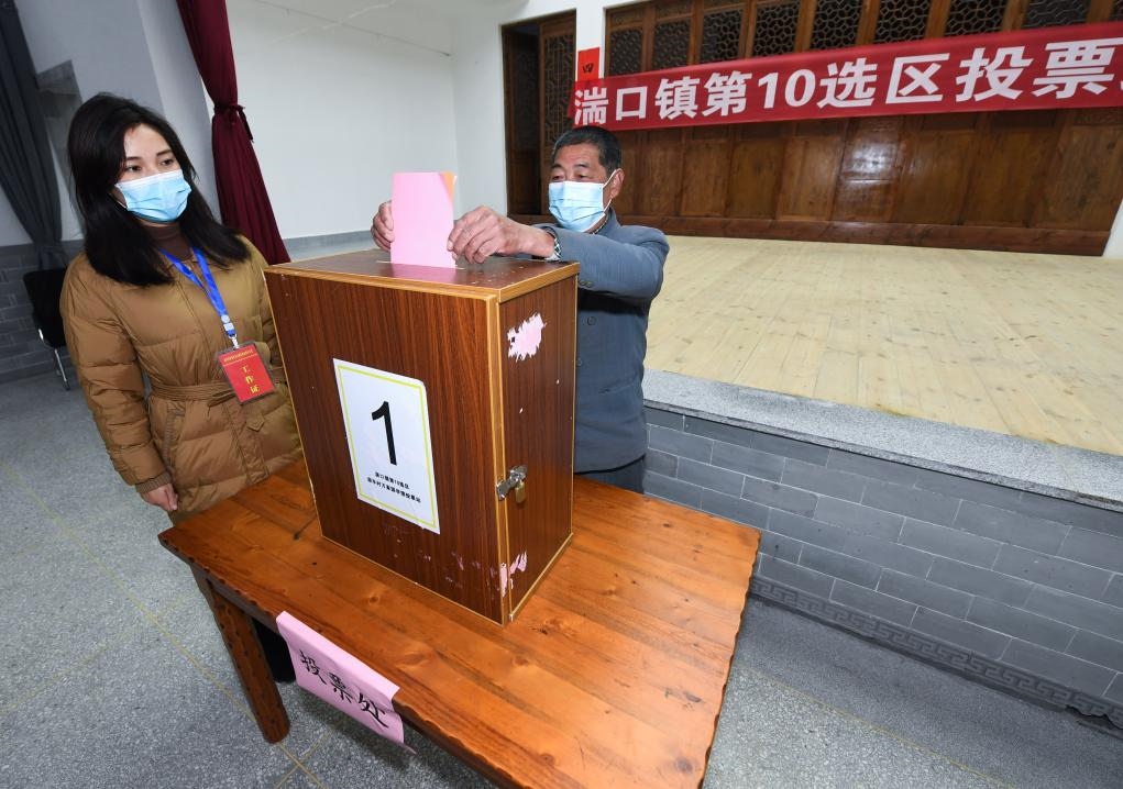 2021年12月14日，在浙江省杭州市臨安區(qū)湍口鎮(zhèn)迎豐村的基層投票點，村民在參加投票，村級監(jiān)察聯(lián)絡(luò)員監(jiān)票。新華社記者 徐昱 攝